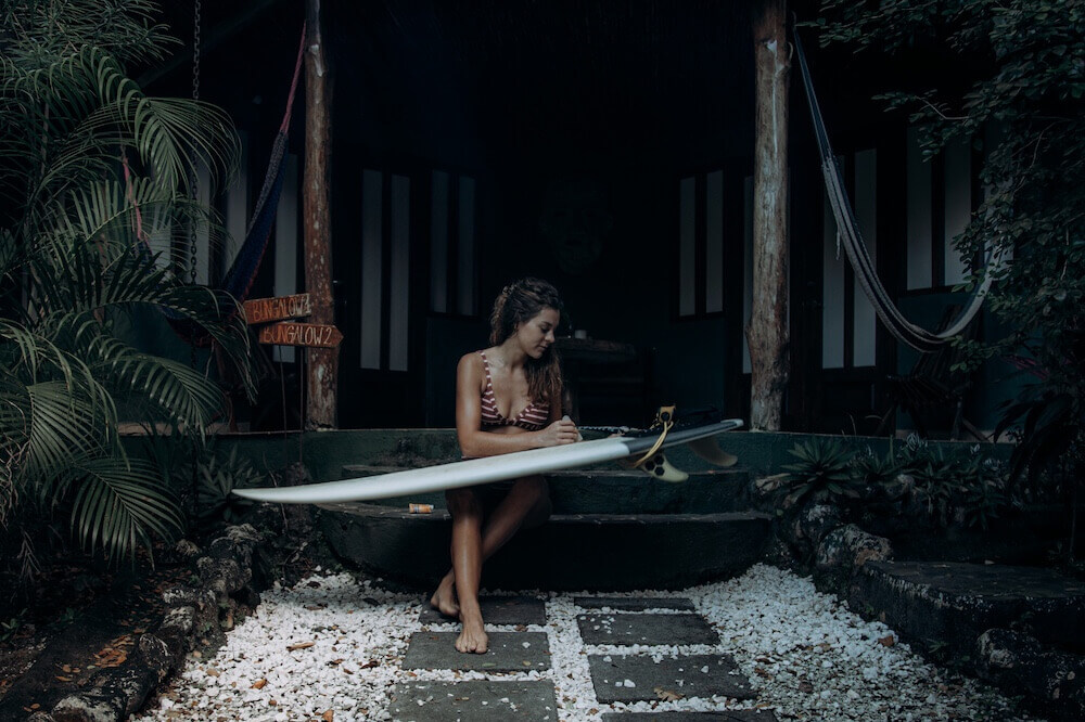 Surferin mit Surfboard und Surf-Bikini von Sisstrevolution